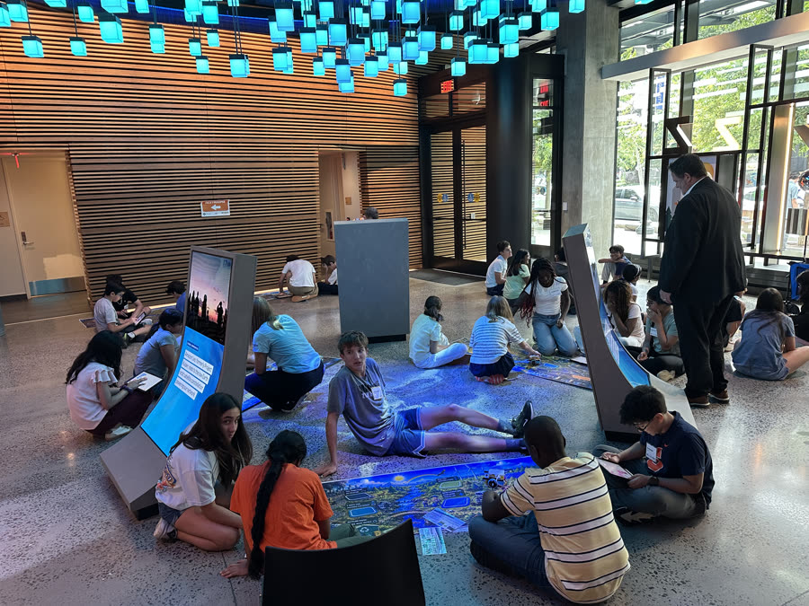 Orblynx students exploring an interactive exhibit during a site visit at Amazon headquarters