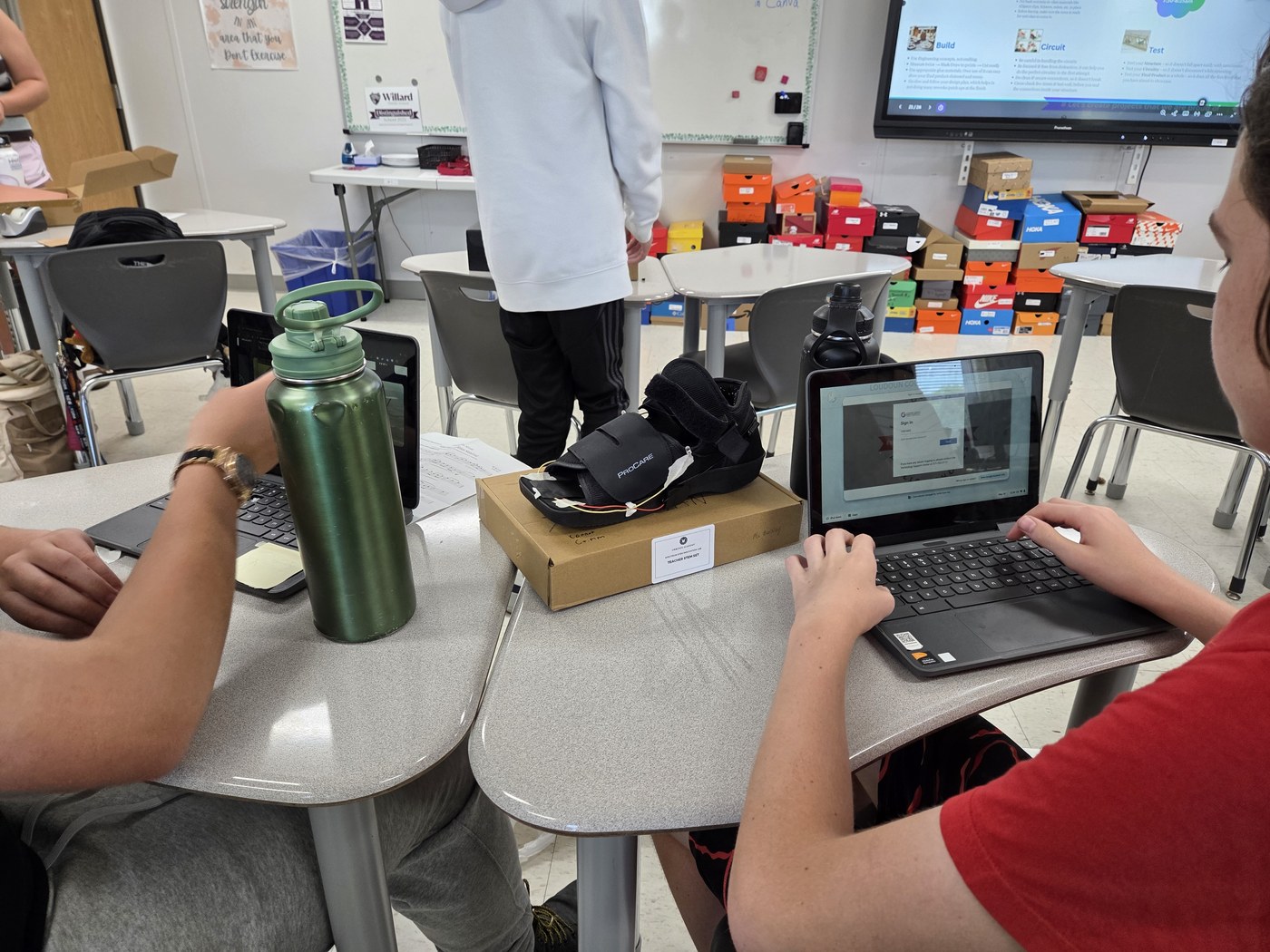Students testing a sensor-wired walking boot prototype during a build and test session