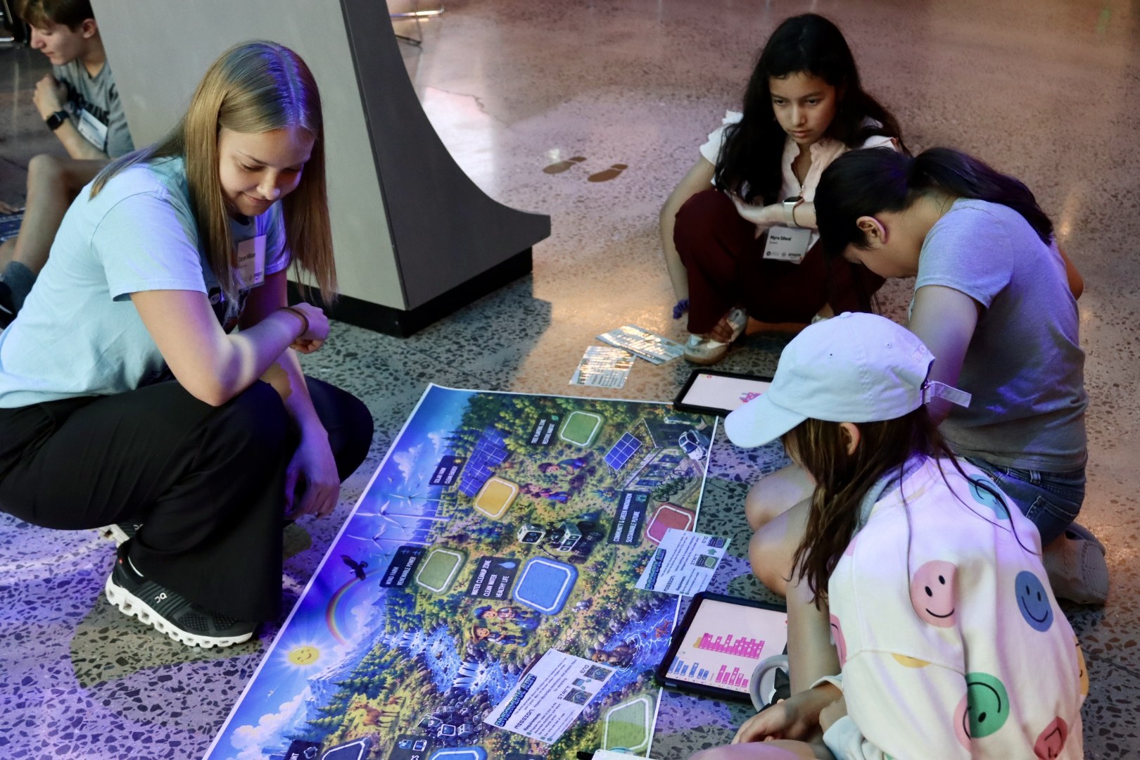Orblynx students collaborating with tablets around a sustainable-city robotics challenge map